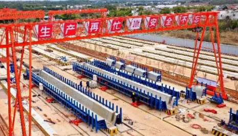 春節(jié)期間高速公路工程建設(shè)者用電動(dòng)葫蘆吊運(yùn)板材